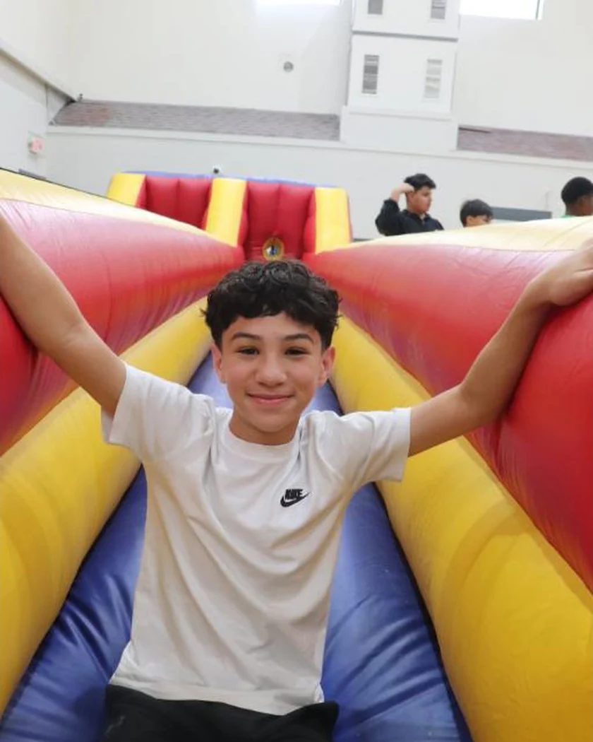 A student on the inflatable slide at a school fun day